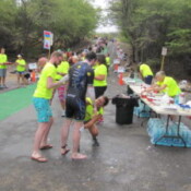 Volunteers load an athlete up with sunscreen before he heads out on the bike